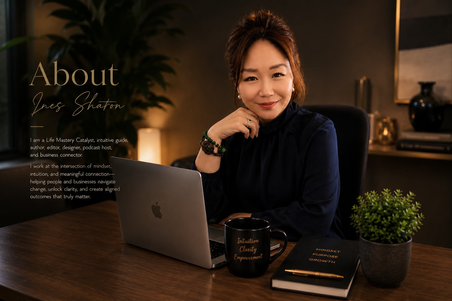 Ines Sharon seated at a desk in a dark navy professional portrait